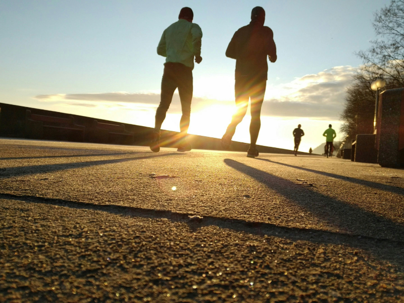 Man running at sunrise showing best time to work out in the morning