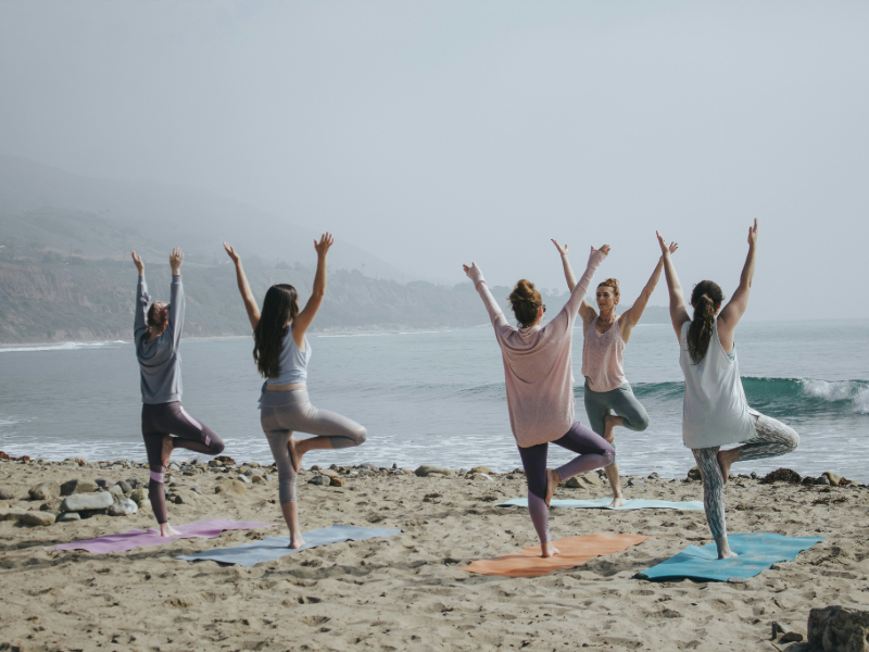 Person practicing yoga at sunrise as a morning exercise