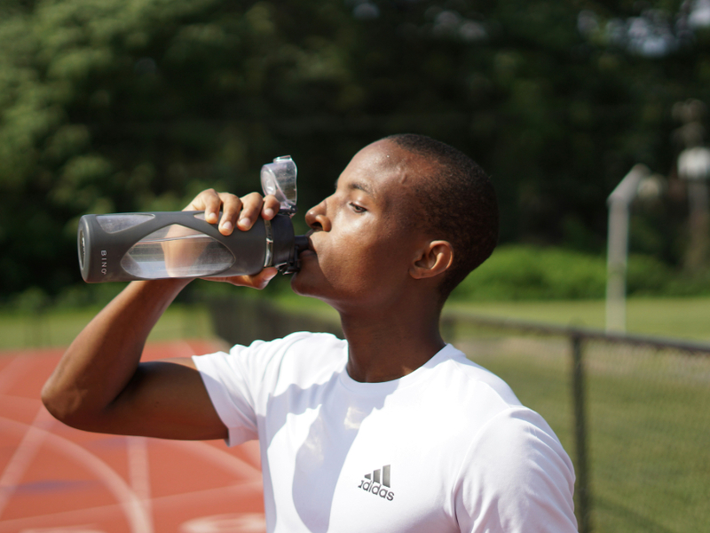 A Man hydrating with water after a workout for better recovery.
