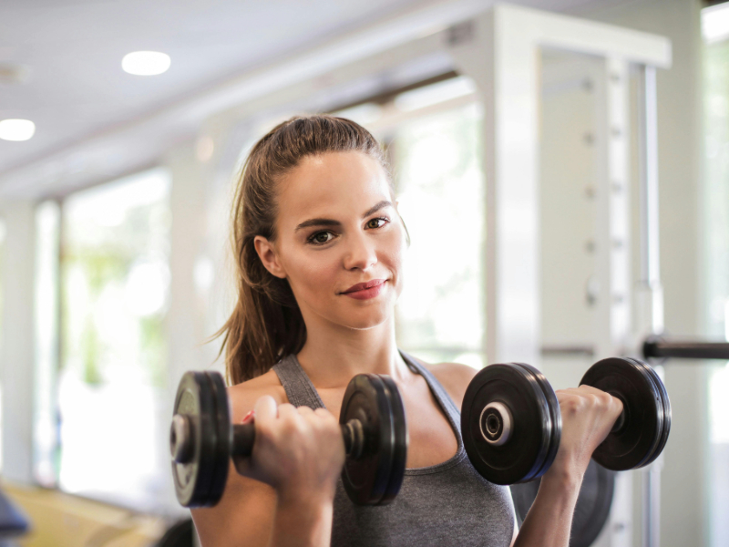 Beginner performing strength training with light dumbbells at home