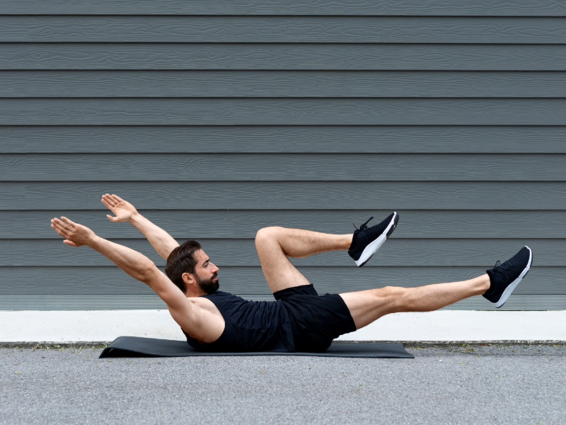 Man performing the dead bug exercise for beginner core strength training.