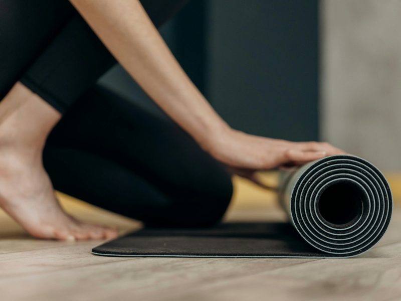 Essential home workout equipment for beginners including a yoga mat and resistance bands
