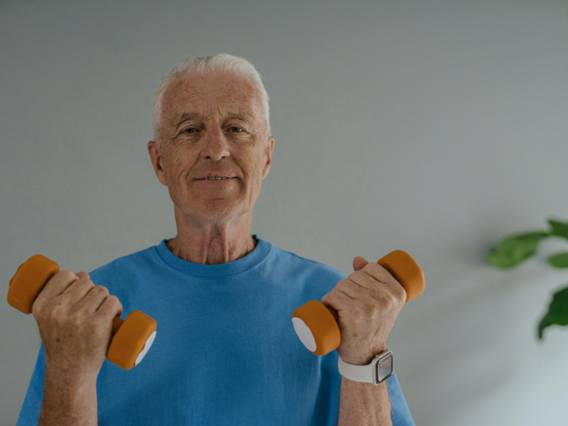 Beginner using home workout equipment like dumbbells in a small living room