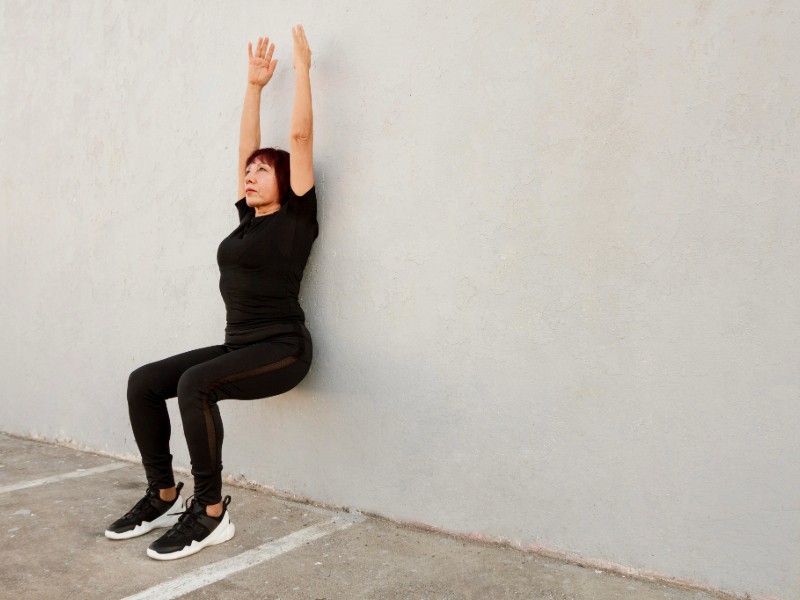 Beginner doing wall angels as part of posture exercises