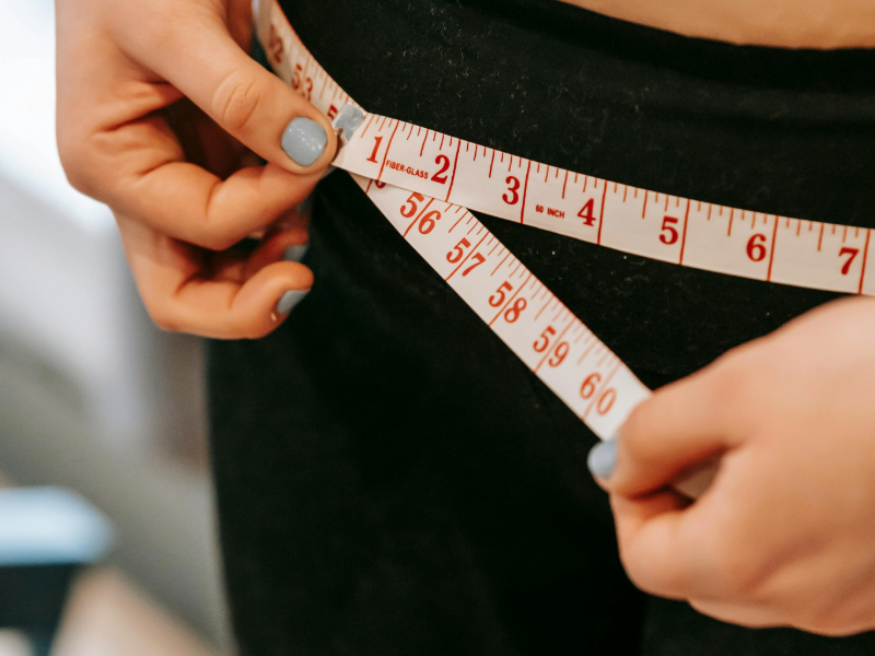 Beginner tracking body measurements with tape measure.