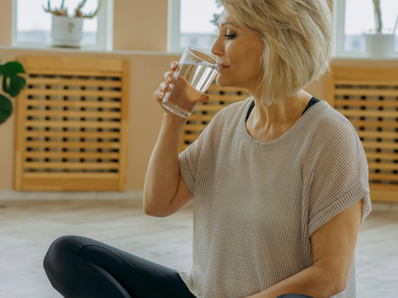 Happy woman over 40 hydrating after beginner workout